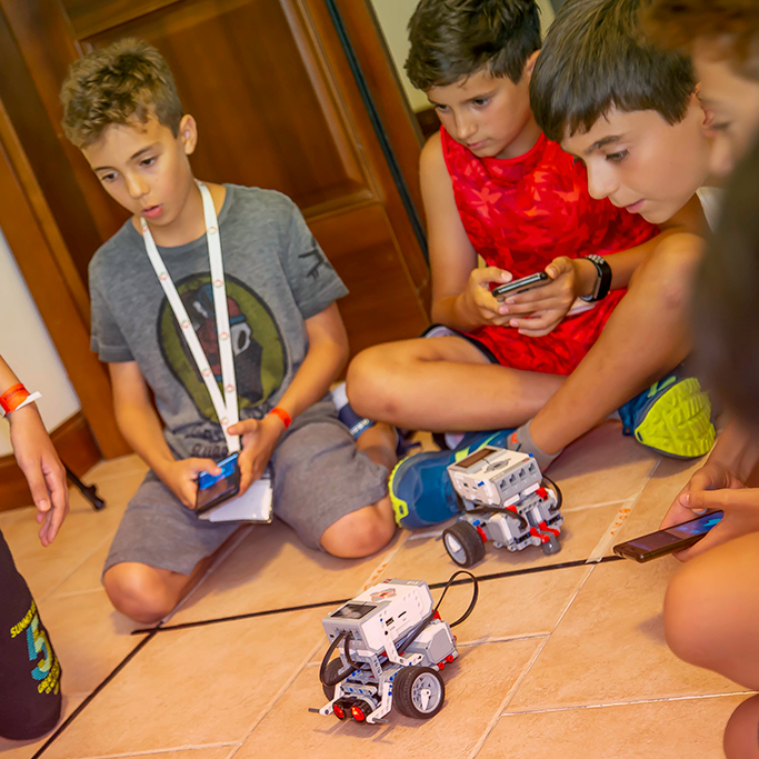 Ragazzi programmano gli Mbot durante uno STEAMcamp